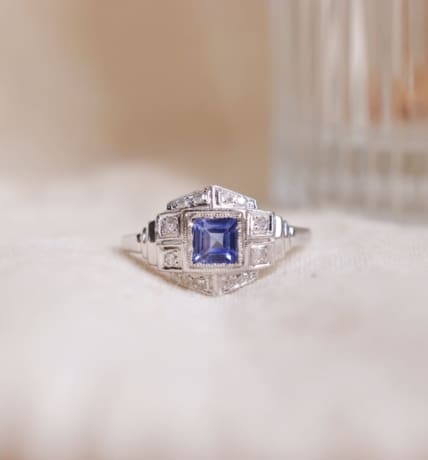 Bague style Art Déco en Or blanc 18 carats et Platine de forme hexagonale sertie d'un Saphir bleu jean carré dans un entourage de Diamants