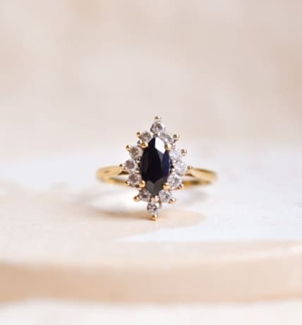 Bague Marquise en Or jaune 18 carats centrée d'un Saphir serti griffes entouré d'Oxydes