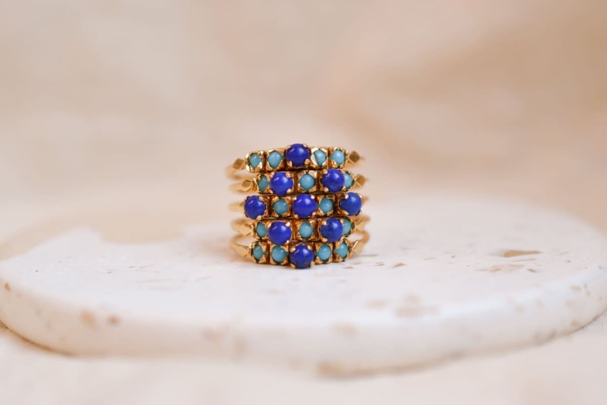 Bague semainier composée de 5 anneaux réunis par une agrafe ornés de cabochons de Turquoises et Lapis Lazulis