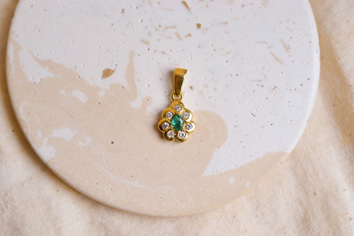 Pendentif Marguerite en Or jaune 18 carats centrée d'une Emeraude taille poire sertie griffes dans un entourage de Diamants