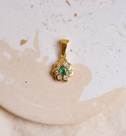 Pendentif Marguerite en Or jaune 18 carats centrée d'une Emeraude taille poire sertie griffes dans un entourage de Diamants