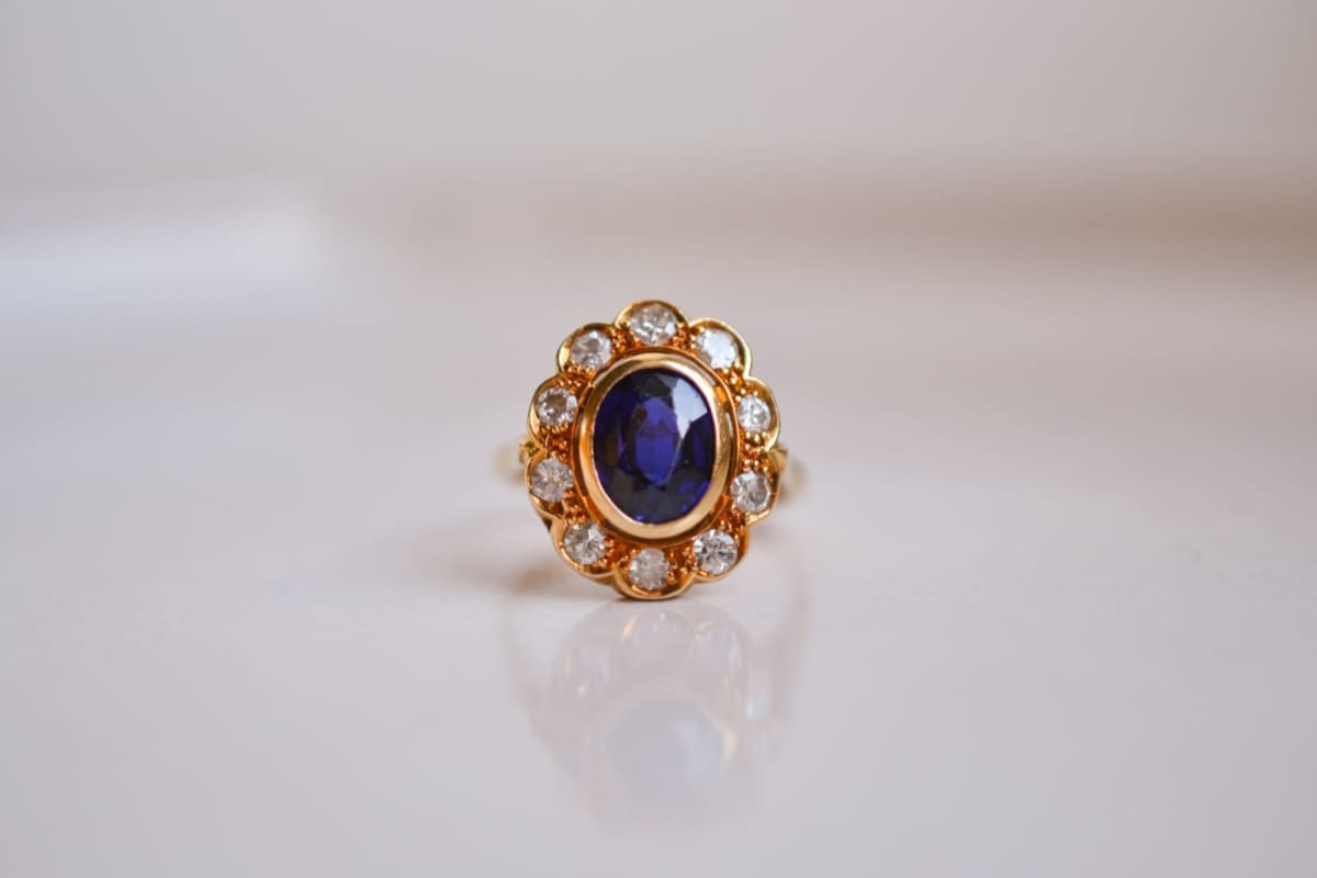 Bague Marguerite en Or jaune 18 carats centrée d'un Saphir dans un entourage de Diamants taille brillant