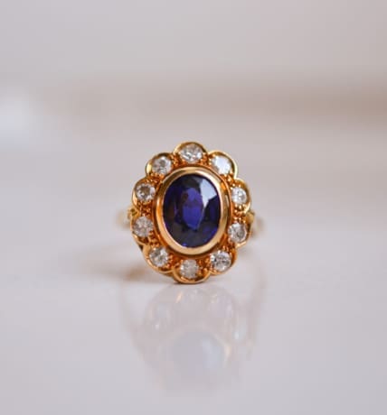 Bague Marguerite en Or jaune 18 carats centrée d'un Saphir dans un entourage de Diamants taille brillant