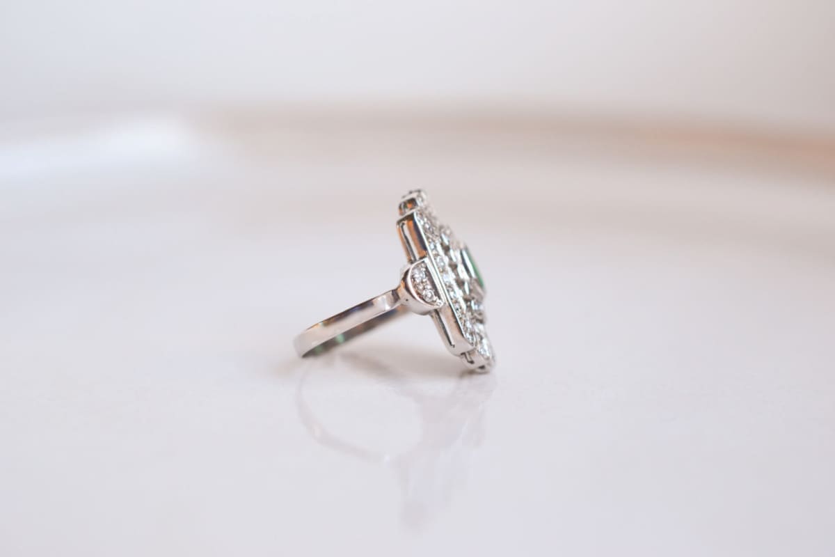 Bague Marquise ancienne en Or blanc 18 carats sertie d'une Émeraude dans un entourage de Diamants
