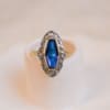 Bague Navette Art Déco 2 Ors centrée d'une pierre bleue entourée de pierres blanches