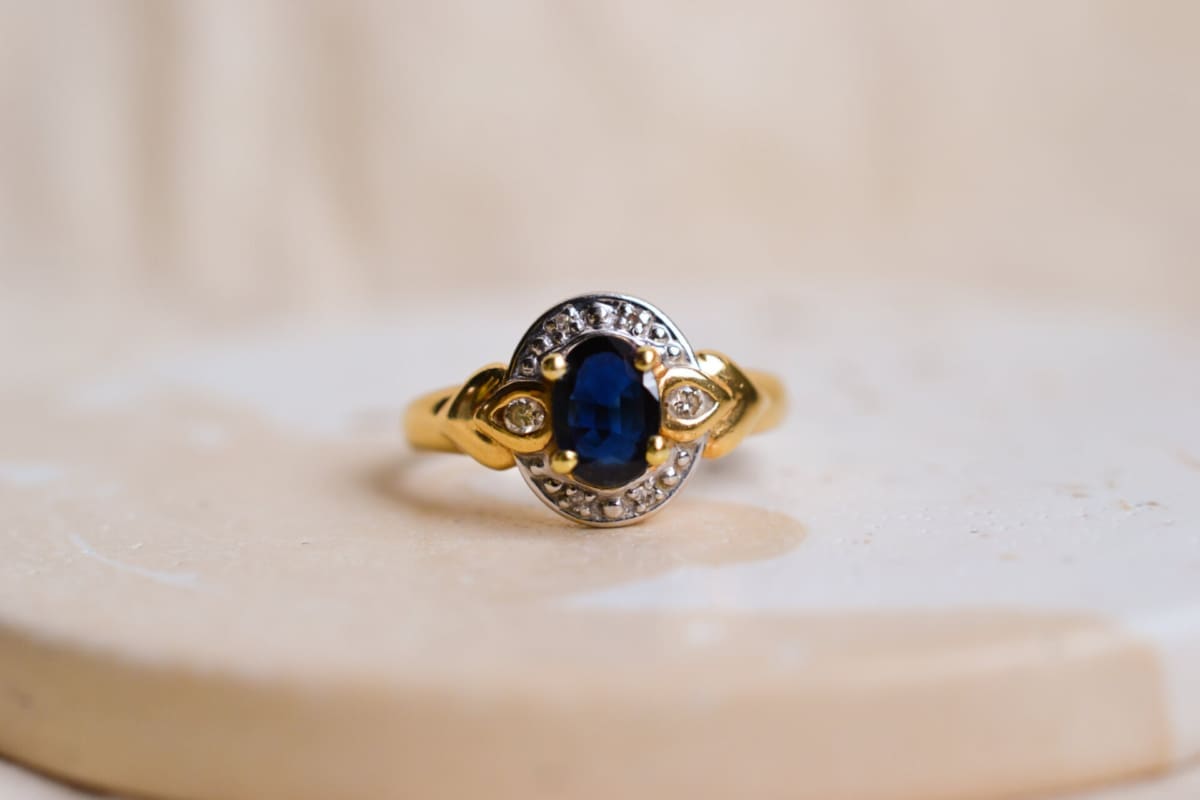 Bague ancienne en Or jaune et Or blanc 18 carats centrée d'un Saphir entouré de Diamants
