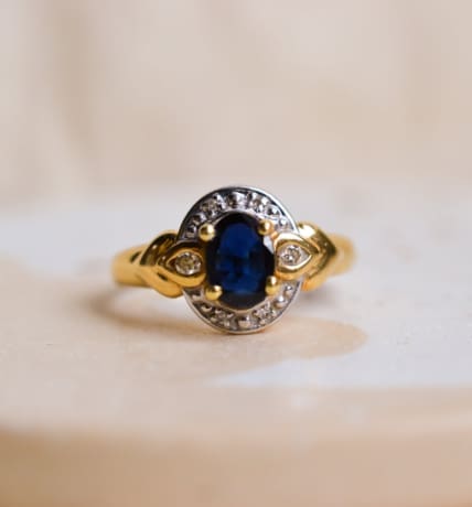Bague ancienne en Or jaune et Or blanc 18 carats centrée d'un Saphir entouré de Diamants