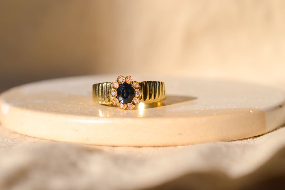 Bague fleur striée en Or jaune 18 carats centrée d'un Saphir dans un entourage de Diamants