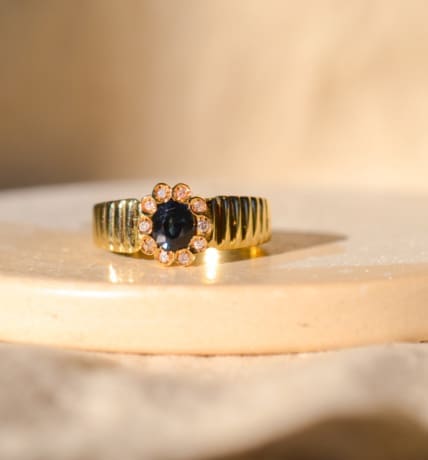 Bague fleur striée en Or jaune 18 carats centrée d'un Saphir dans un entourage de Diamants