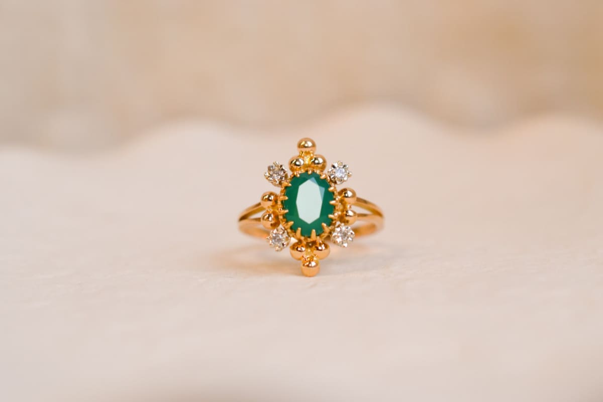 Bague Marguerite ancienne en Or jaune 18 carats centrée d'une Émeraude sertie griffes entourée de Diamants