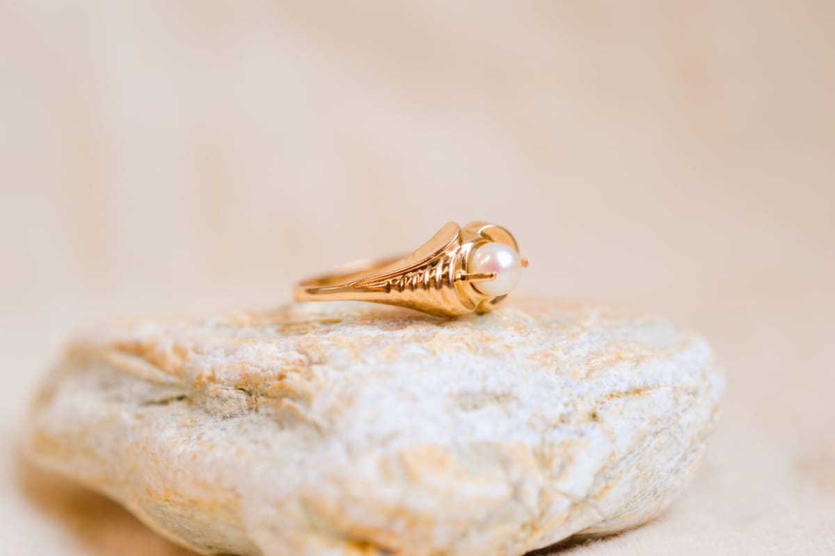 Bague ancienne en Or jaune 18 carats sertie griffes d'une Perle dans un décor de volute