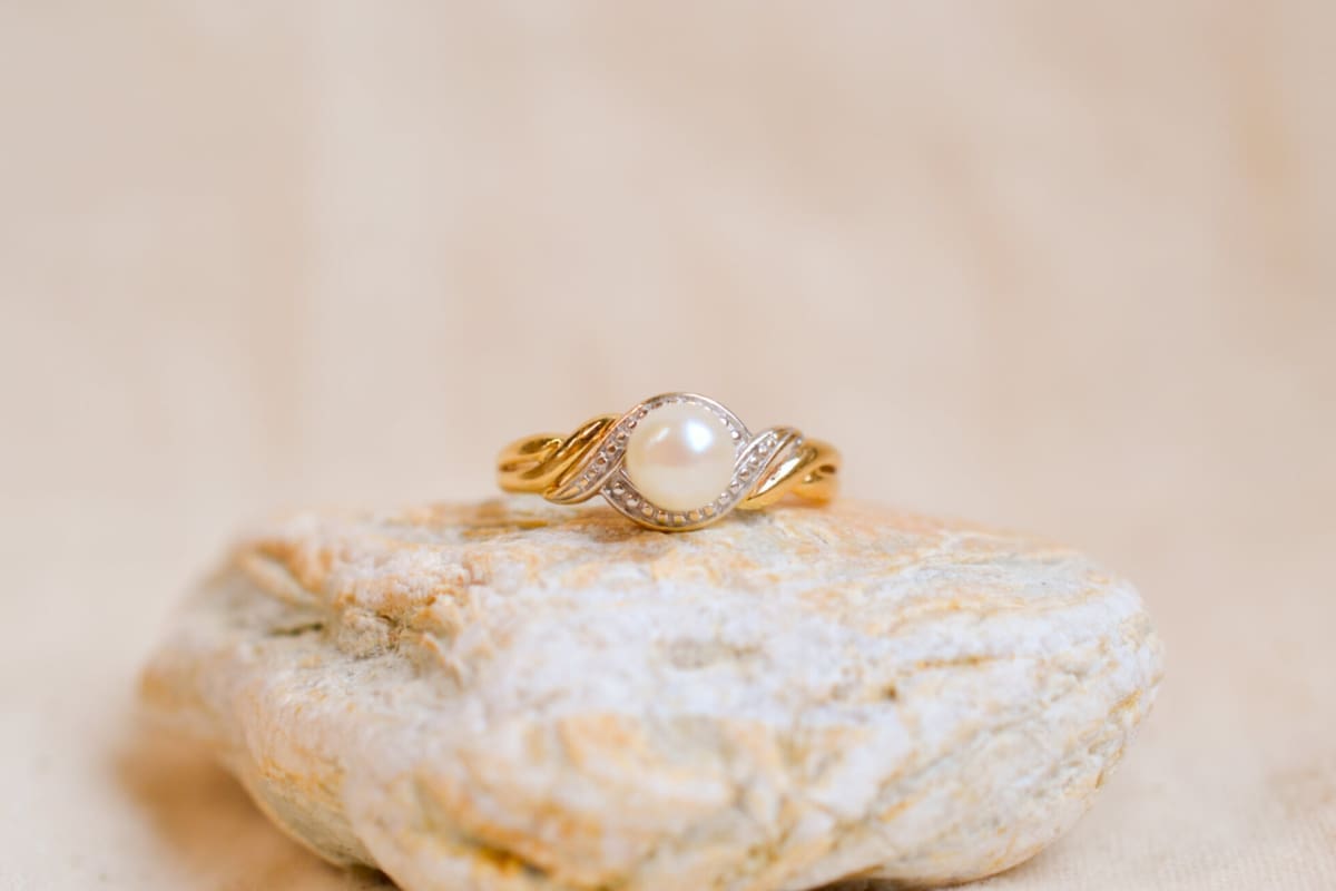 Bague ancienne en Or jaune et Or blanc 18 carats centrée d'une Perle dans un décor entrelacé