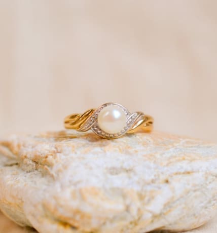Bague ancienne en Or jaune et Or blanc 18 carats centrée d'une Perle dans un décor entrelacé
