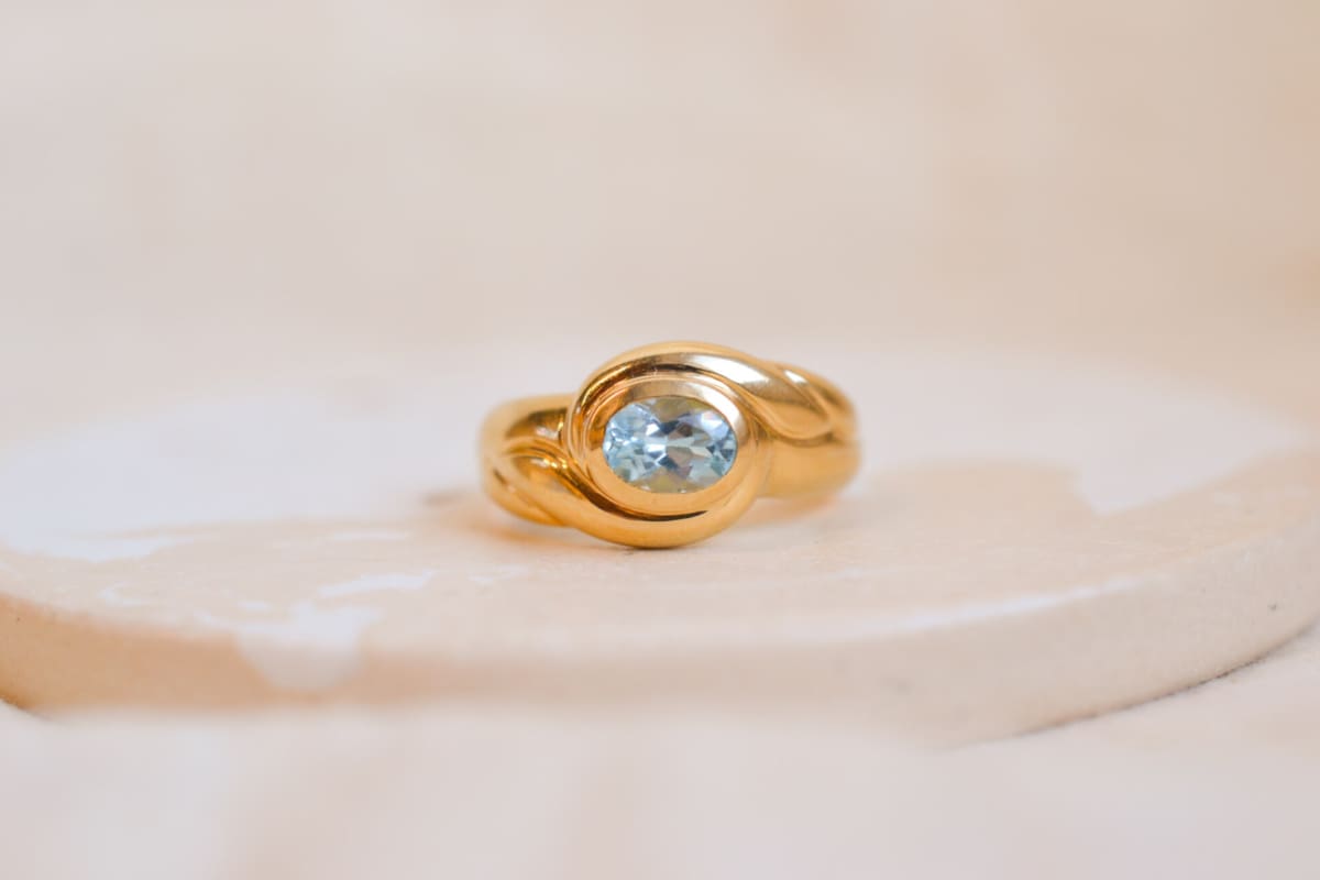 Bague jonc Vintage sertie d'une Topaze dans un décor de volute