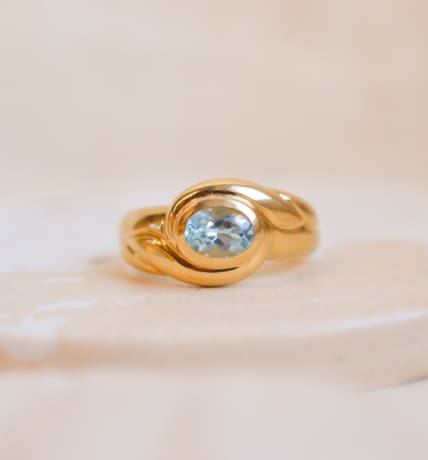 Bague jonc Vintage sertie d'une Topaze dans un décor de volute
