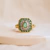 Bague octogonale en Or jaune 18 carats ornée d'une Émeraude ovale entourée de Diamants et d'Émeraudes calibrées
