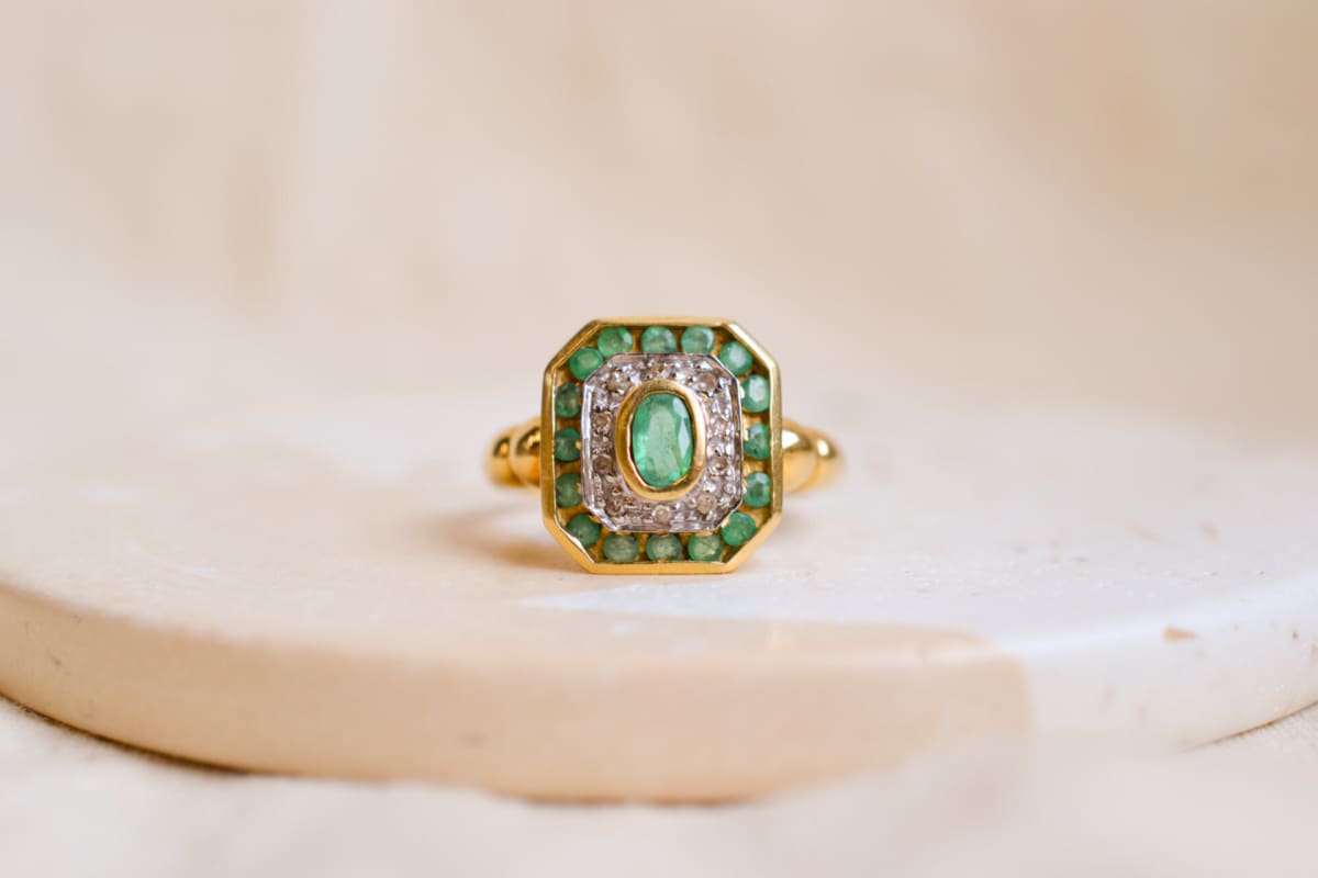 Bague octogonale en Or jaune 18 carats ornée d'une Émeraude ovale entourée de Diamants et d'Émeraudes calibrées