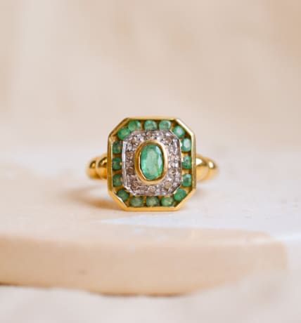 Bague octogonale en Or jaune 18 carats ornée d'une Émeraude ovale entourée de Diamants et d'Émeraudes calibrées