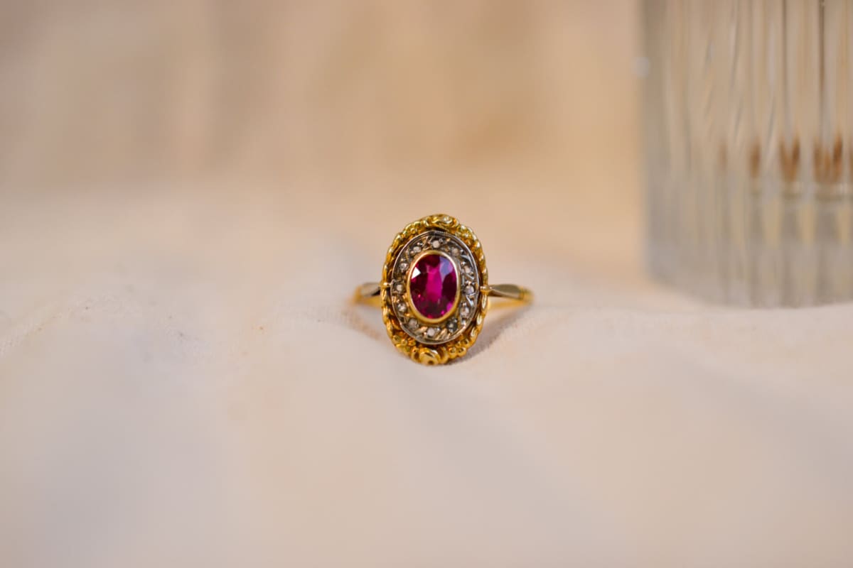 Bague ovale en Or jaune et Or blanc 18 carats centrée d'un Rubis entouré de roses de Diamants