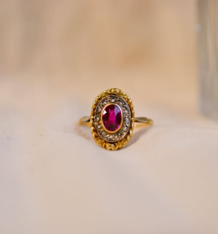 Bague ovale en Or jaune et Or blanc 18 carats centrée d'un Rubis entouré de roses de Diamants