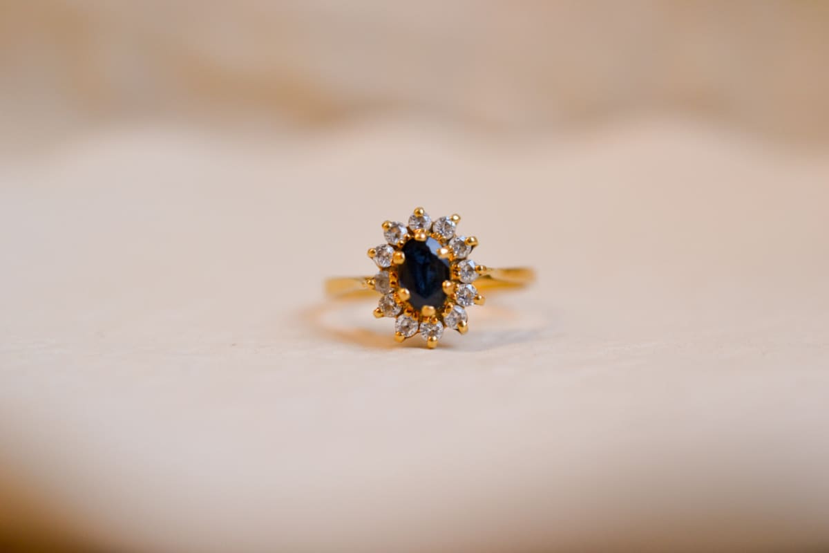 Bague Marguerite ancienne en Or jaune 18 carats centrée d'un Saphir entouré de pierres blanches