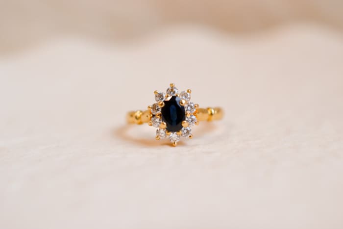 Bague Marguerite en Or jaune 18 carats centrée d'un Saphir entouré de pierres blanches