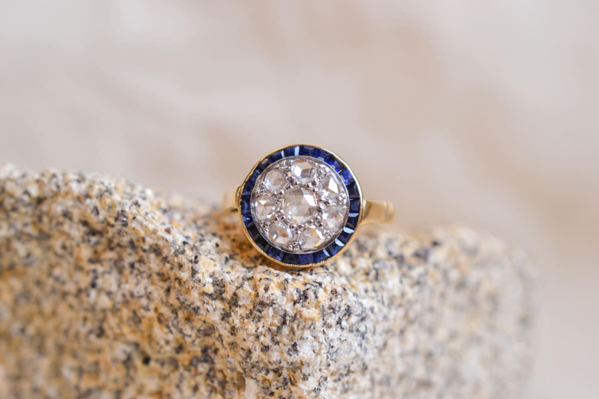 Bague ancienne circulaire en Or jaune 18 carats centrée de Diamants entourés de Saphirs calibrés
