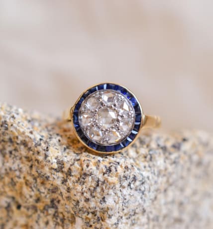 Bague ancienne circulaire en Or jaune 18 carats centrée de Diamants entourés de Saphirs calibrés