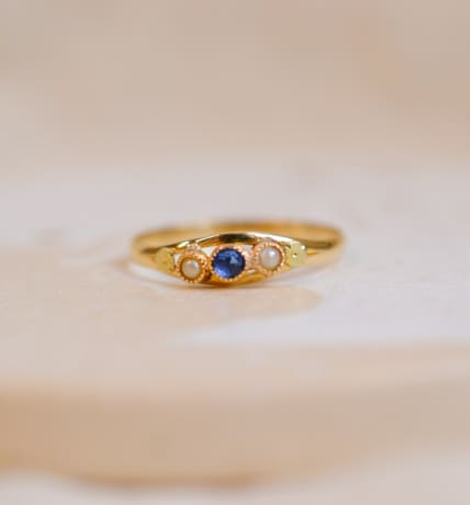 Bague ancienne en Or jaune 18 carats centrée d'un Saphir de synthèse épaulé par 2 Perles