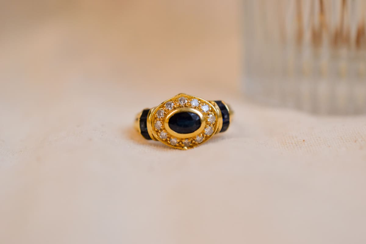 Bague ancienne en Or jaune 18 carats centrée d'un Saphir entouré de Diamants