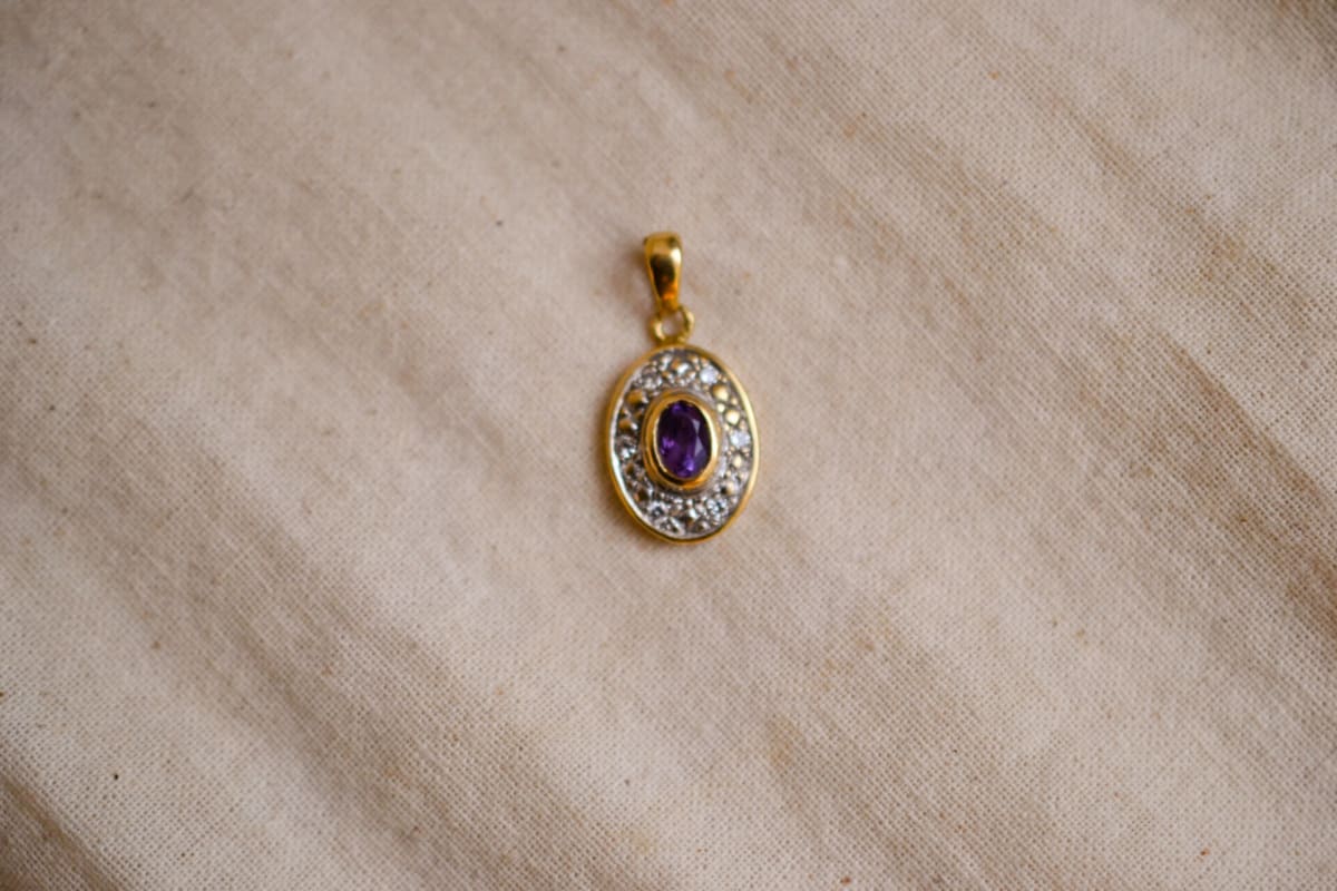 Pendentif oval en Or jaune 18 carats centré d'une Améthyste entourée de Diamants