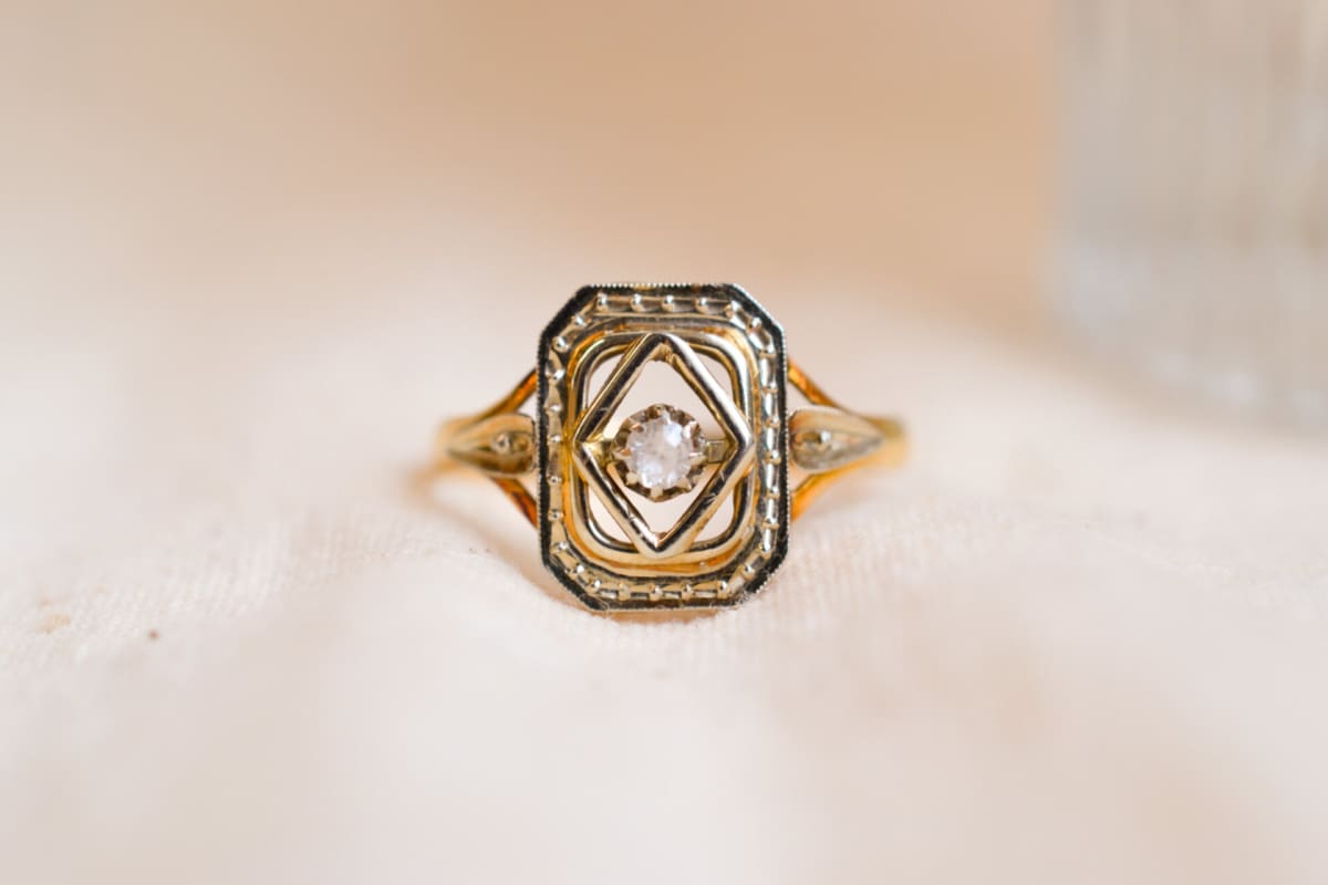 Bague Art Déco en Or jaune et Or blanc 18 carats centrée d'une pierre blanche dans un décor octogonal ajouré