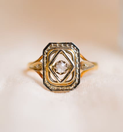 Bague Art Déco en Or jaune et Or blanc 18 carats centrée d'une pierre blanche dans un décor octogonal ajouré