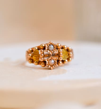 Bague Art Nouveau en Or rose 18 carats sertie de Perles dans un décor de fleur épaulées par des noeuds en Or vert entourés de billes d'Or