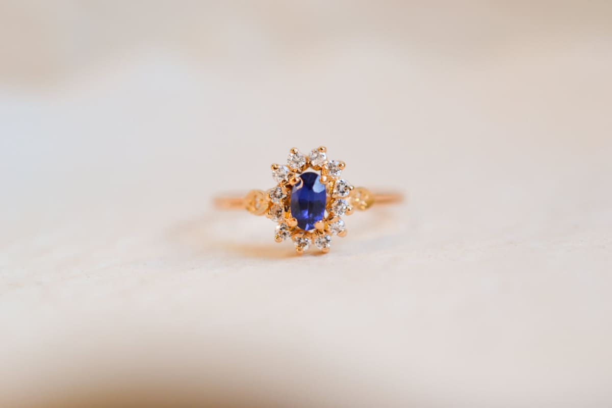Bague Marguerite ancienne en Or jaune 18 carats centrée d'un Saphir de synthèse entouré d'Oxydes de zirconium