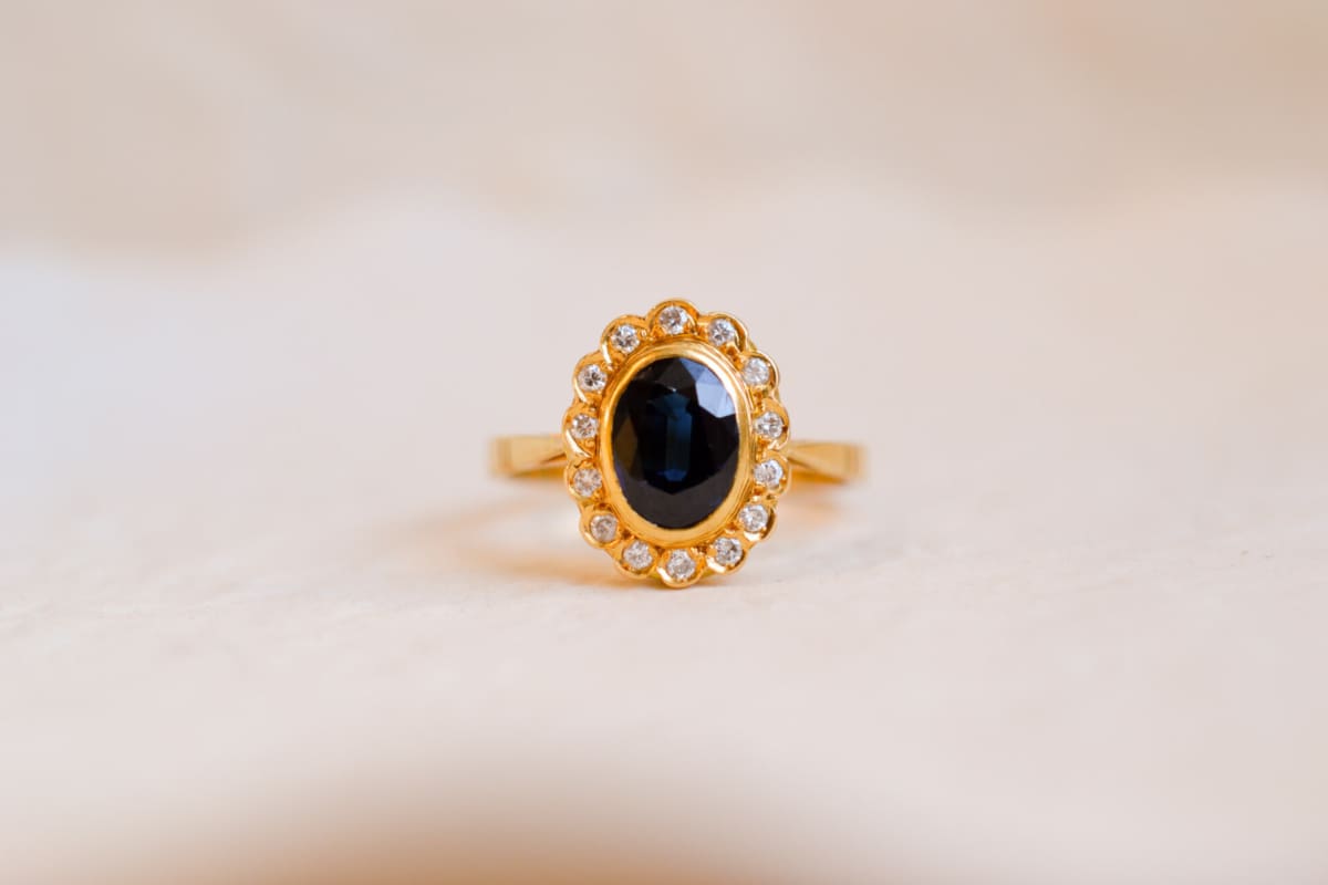 Bague Marguerite ancienne en Or jaune 18 carats centrée d'un Saphir entouré de Diamants