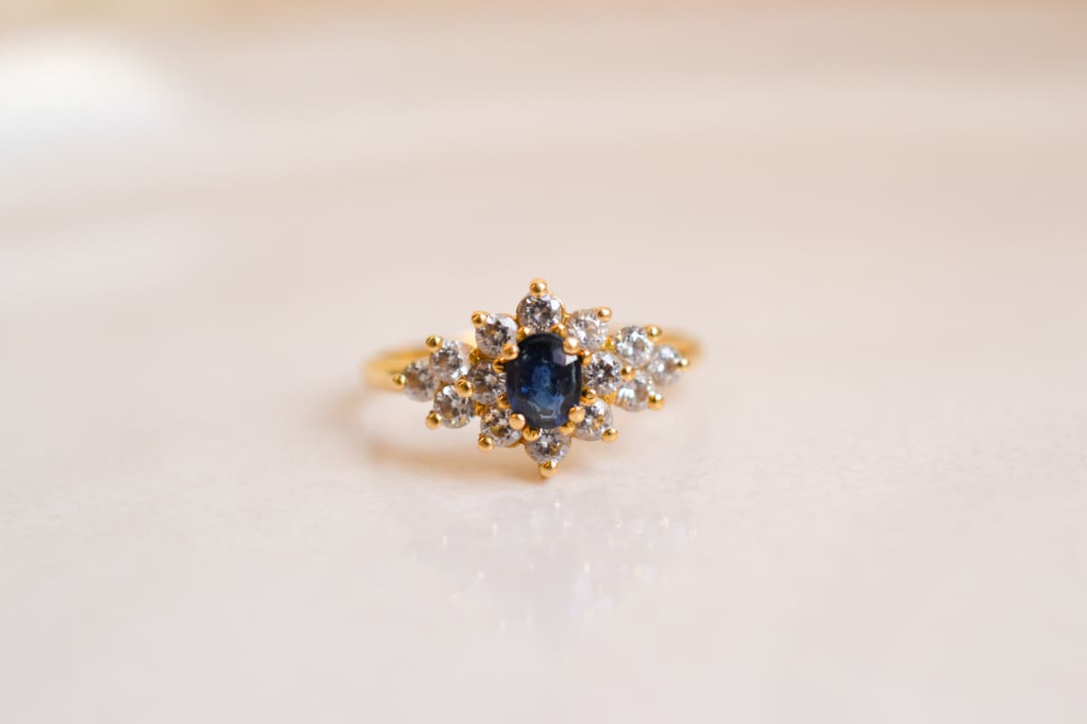 Bague Marguerite en Or jaune 18 carats centrée d'un Saphir épaulé d'Oxydes