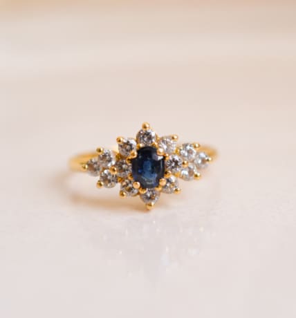 Bague Marguerite en Or jaune 18 carats centrée d'un Saphir épaulé d'Oxydes