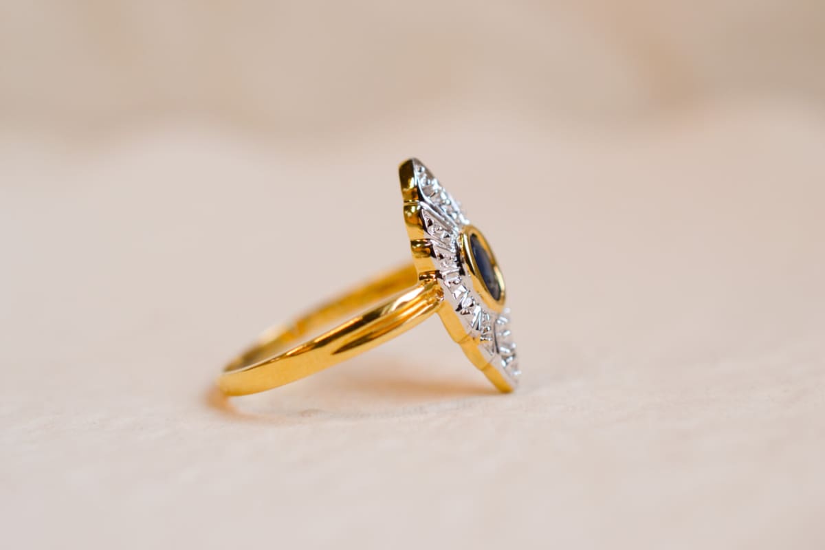 Bague Marquise ancienne en Or jaune et Or blanc 18 carats sertie clos d'un Saphir sur une illusion de pavage