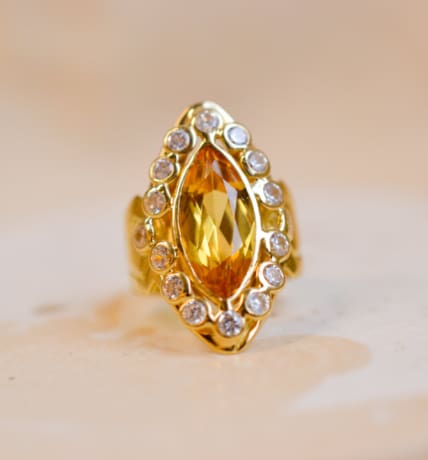 Bague Marquise en Or jaune centree d'un Saphir jaune entouré de pierres blanches