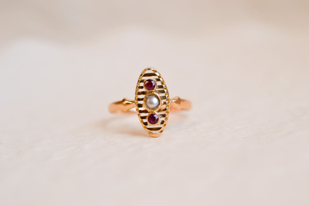 Bague Navette en Or jaune 18 carats centrée d'une Perle entourée de pierres rouges