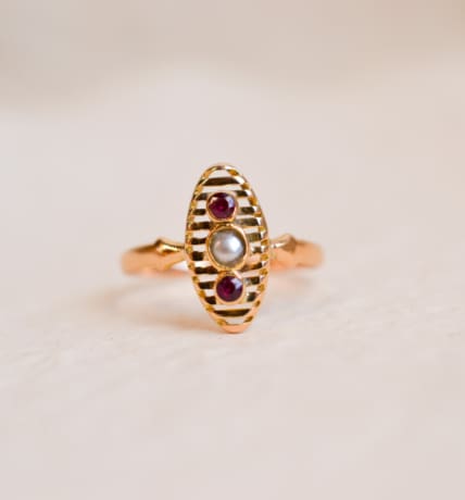 Bague Navette en Or jaune 18 carats centrée d'une Perle entourée de pierres rouges