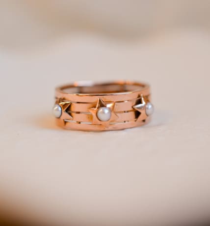 Bague bandeau ancienne en Or rose 18 carats ornée de Perles dans des décors étoilés
