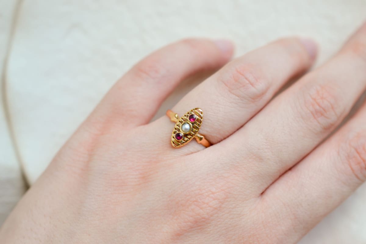 Bague de fiançailles ancienne en Or jaune 18 carats centrée d'une Perle entourée de pierres rouges