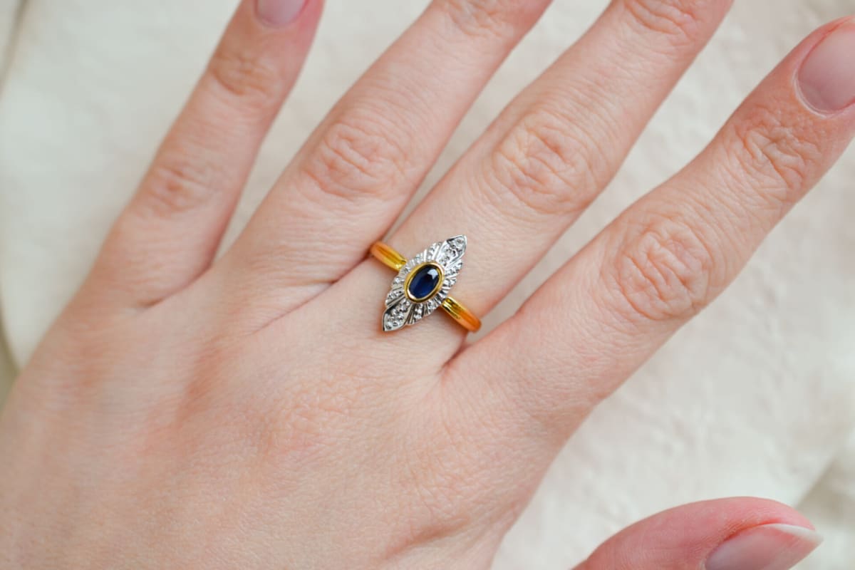 Bague de fiançailles ancienne en Or jaune et Or blanc 18 carats centrée d'un Saphir serti clos sur une illusion de pavage