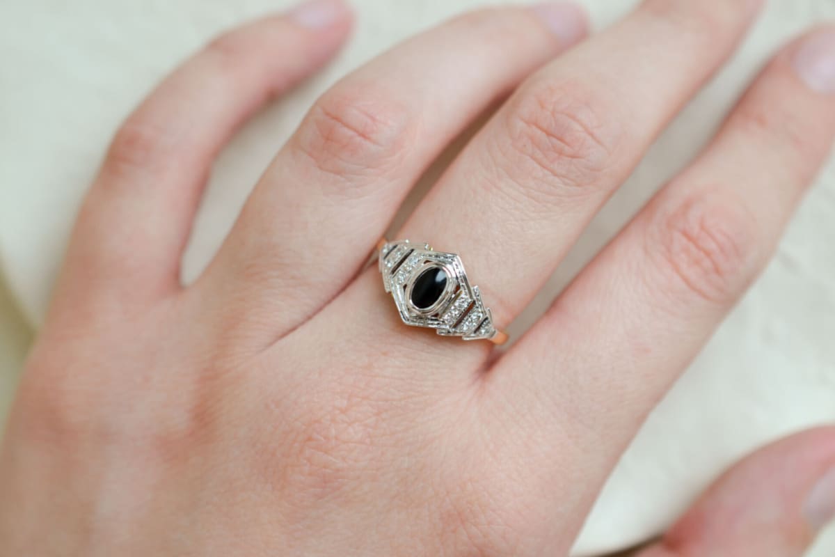 Bague de fiançailles ancienne en Or jaune et blanc 18 carats ornée d'un cabochon d'Onyx épaulé par 10 Diamants