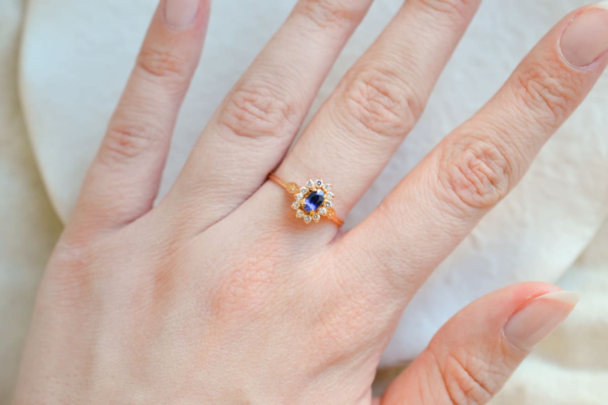 Bague de fiançailles en Or jaune 18 carats centrée d'un Saphir de synthèse entouré d'Oxydes de zirconium