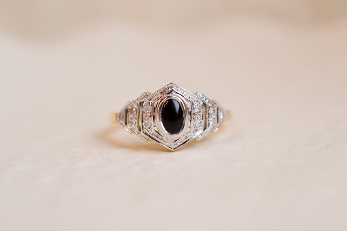 Bague hexagonale en Or jaune et blanc 18 carats centrée d'un cabochon d'Onyx épaulé par 10 Diamants
