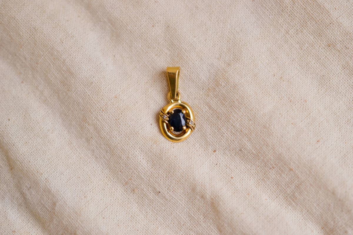 Pendentif ancien en Or jaune 18 carats serti griffes d'un Saphir épaulé par 2 Diamants dans un décor ajouré