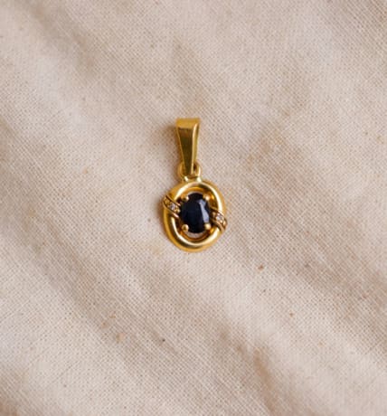 Pendentif ancien en Or jaune 18 carats serti griffes d'un Saphir épaulé par 2 Diamants dans un décor ajouré